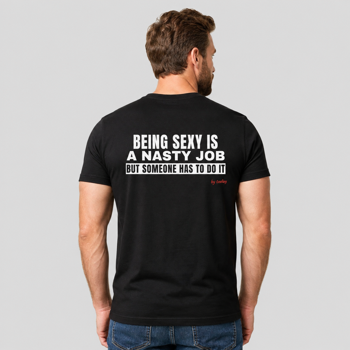 Man from behind wearing a black t shirt with Being Sexy Is A Nasty Job But Someone Has To Do It printed on the back