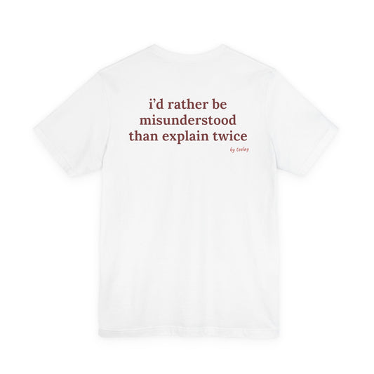 Woman from behind wearing a white oversized t shirt with "I'd Rather Be Misunderstood Than Explain Twice" printed on the back