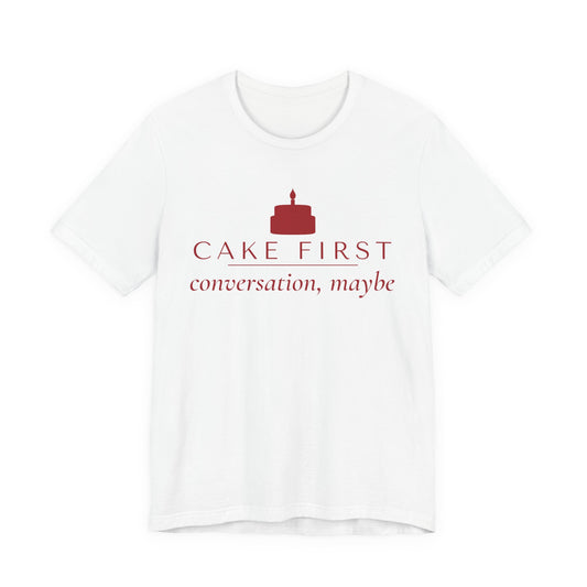 Front of a white t shirt with Cake First, Conversation Maybe printed in red
