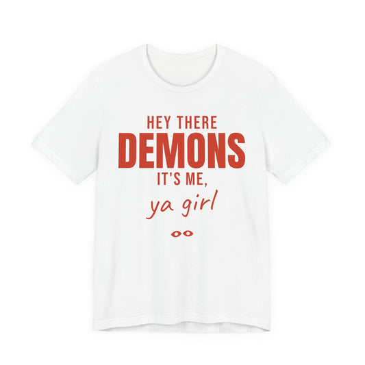 White oversized t shirt with Hey There Demons, It's Me, Ya Girl printed in red on the front