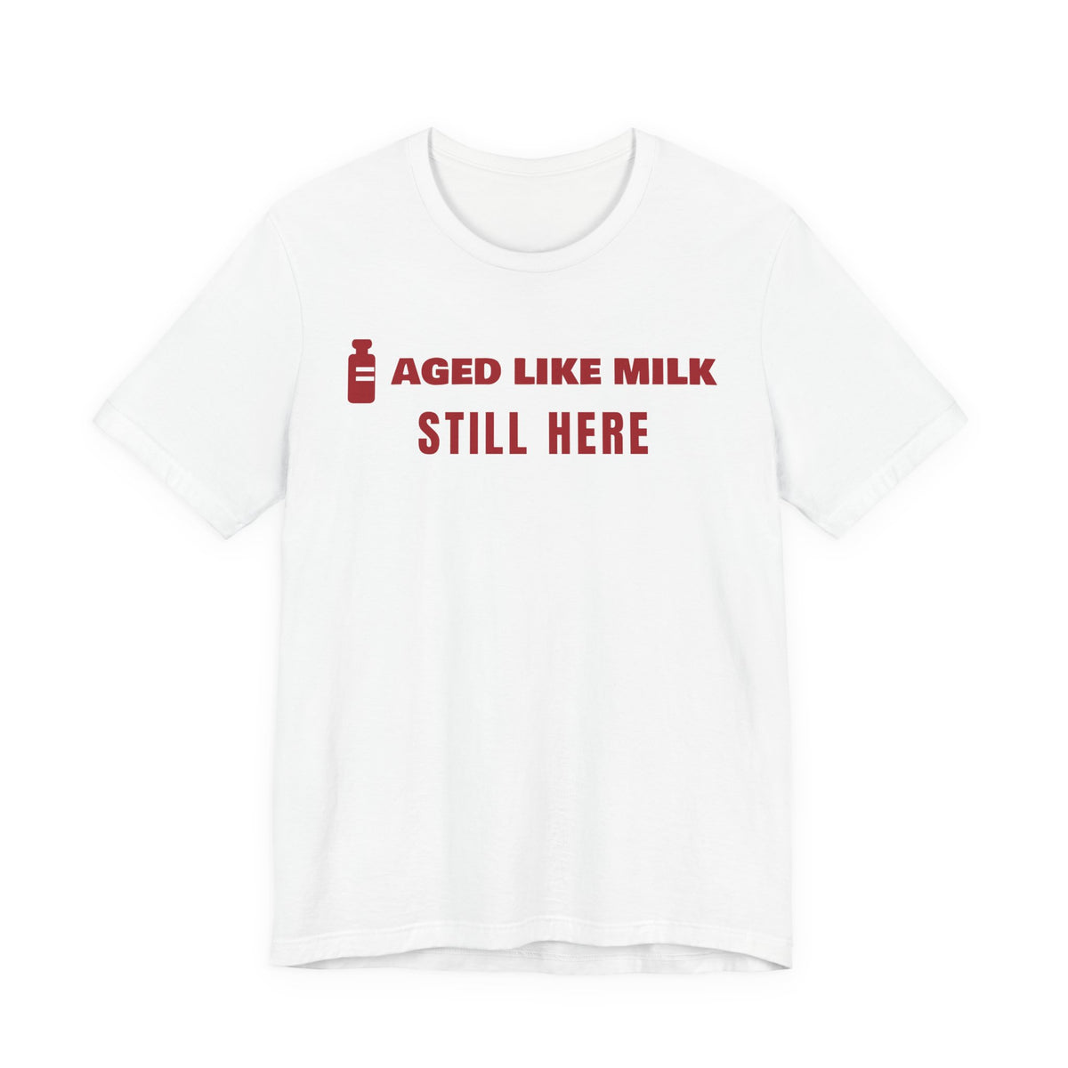 Front of a white t shirt with Aged Like Milk. Still Here. printed in red