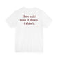 Woman from behind wearing a white oversized t shirt with "They Said Tone It Down. I Didn't." printed on the back
