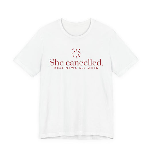 Front of a white t shirt with She Cancelled. Best News All Week. printed in red