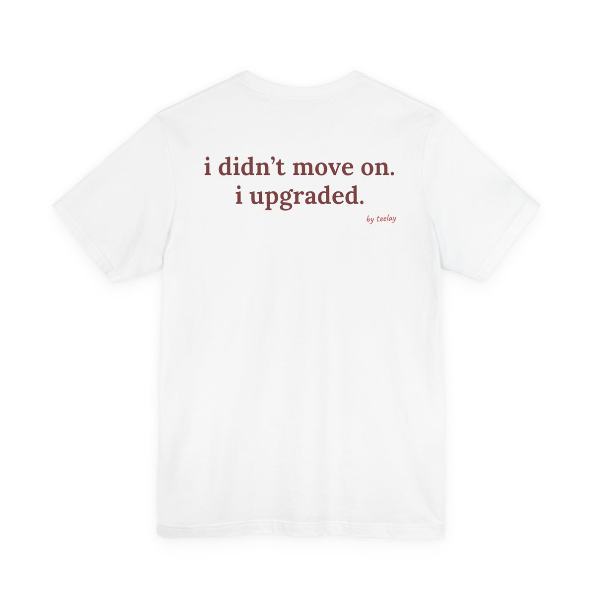 Woman from behind wearing a white oversized t shirt with "I Didn't Move On. I Upgraded." printed on the back