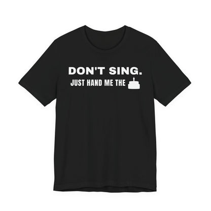 Front of a black t shirt with Don't Sing. Just Hand Me The Cake. printed in white