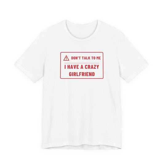 Man wearing a white oversized t shirt with "Don't Talk To Me, I Have A Crazy Girlfriend" printed on the front, warning label design