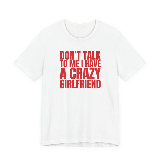 Man wearing a white oversized t shirt with "Don't Talk To Me, I Have A Crazy Girlfriend" printed on the front, bold block design