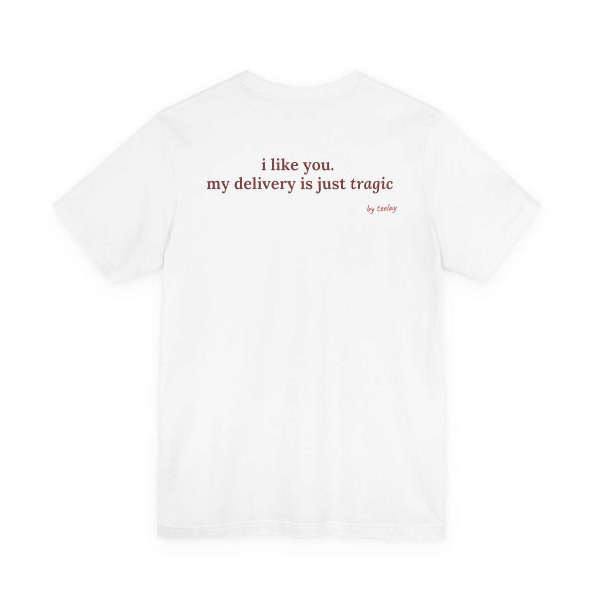 Woman from behind wearing a white oversized t shirt with "I Like You. My Delivery Is Just Tragic" printed on the back