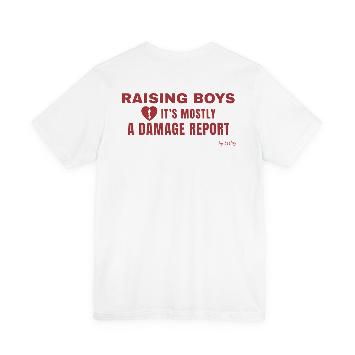 Back of a white t shirt with Raising Boys It's Mostly A Damage Report printed in red