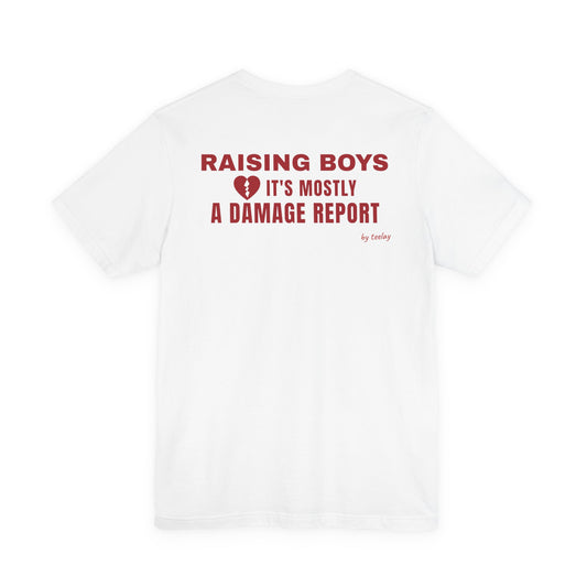 Back of a white t shirt with Raising Boys It's Mostly A Damage Report printed in red