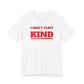 Woman wearing a white oversized t shirt with "I Don't Flirt, I'm Just Kind" printed on the front, varsity design