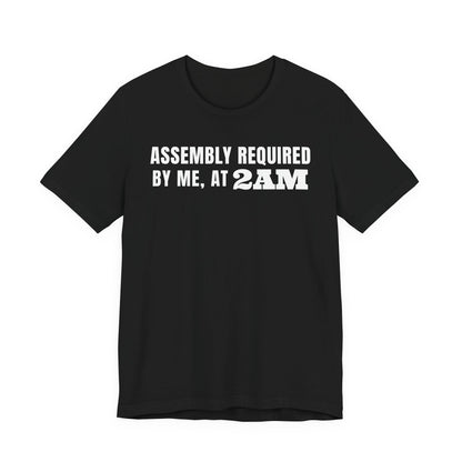 Front of a black t shirt with Assembly Required By Me, At 2AM printed in white