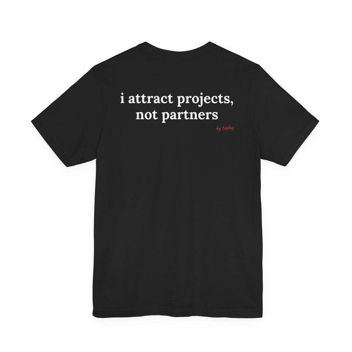 Woman from behind wearing a black oversized t shirt with "I Attract Projects, Not Partners" printed on the back