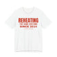 White oversized t shirt with Reheating The Same Costume Since 2014 printed in red on the front