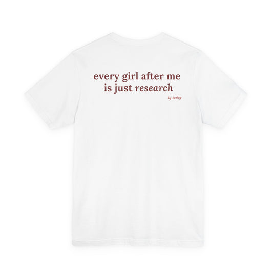 Woman from behind wearing a white oversized t shirt with "Every Girl After Me Is Just Research" printed on the back