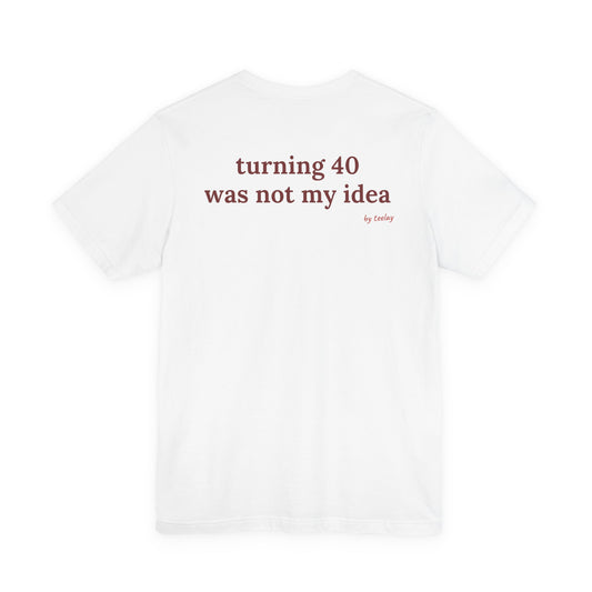 Woman from behind wearing a white oversized t shirt with "Turning 40 Was Not My Idea" printed on the back