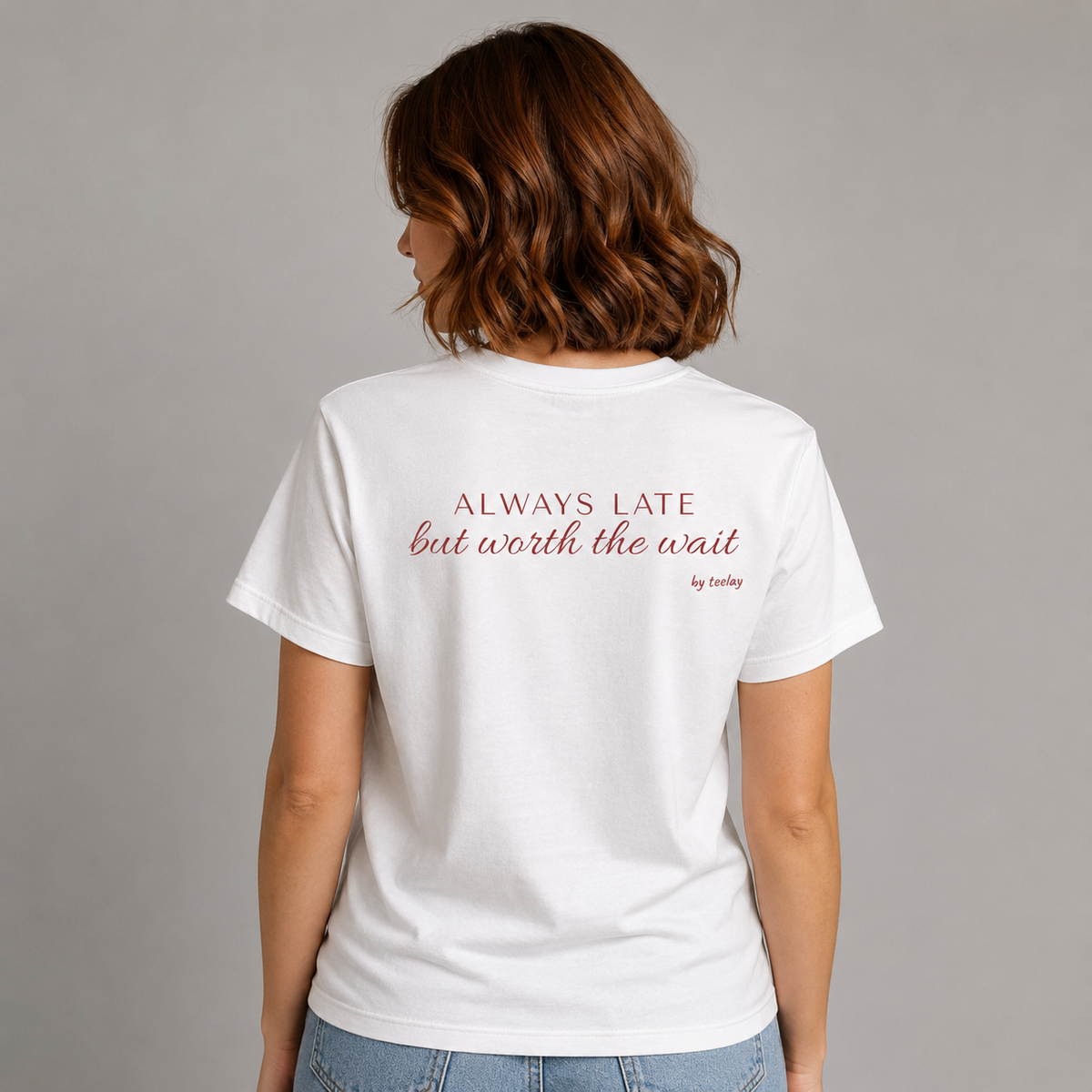 Woman from behind wearing a white t shirt with Always Late But Worth The Wait printed on the back