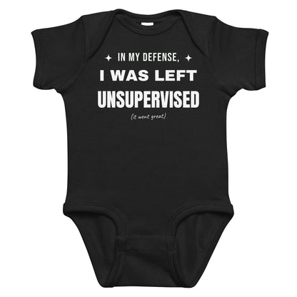 Black baby bodysuit with In My Defense, I Was Left Unsupervised printed in white on the front