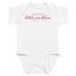 White baby bodysuit with Auntie's Little Problem printed in red on the front