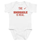 White baby bodysuit with The Snuggle Is Real printed in red on the front