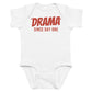 White baby bodysuit with Drama Since Day One printed in red on the front