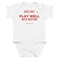 White baby bodysuit with Does Not Play Well With Bedtime printed in red on the front