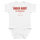 White baby bodysuit with Snack Audit In Progress printed in red on the front