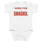 White baby bodysuit with Here For The Snacks printed in red on the front