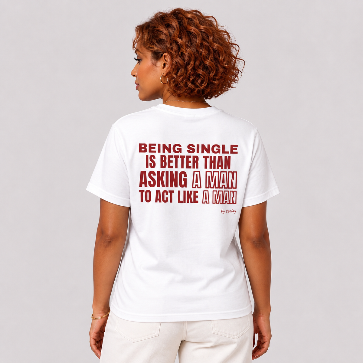 Woman from behind wearing a white t shirt with Being Single Is Better Than Asking A Man To Act Like A Man printed on the back