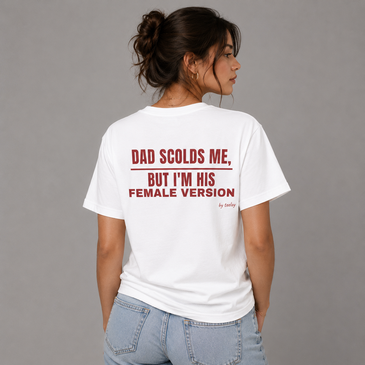 Woman from behind wearing a white t shirt with Dad Scolds Me But I'm His Female Version printed on the back