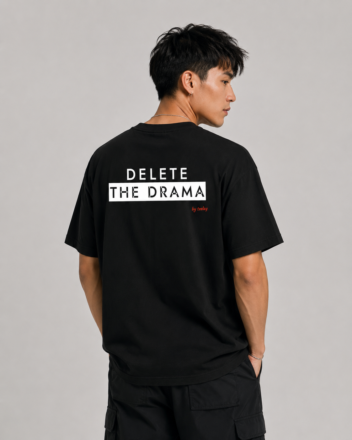 Man from behind wearing a black t shirt with Delete The Drama printed on the back