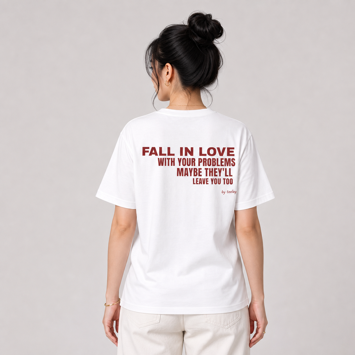 Woman from behind wearing a white t shirt with Fall In Love With Your Problems Maybe They'll Leave You Too printed on the back