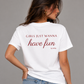 Woman from behind wearing a white t shirt with Girls Just Wanna Have Fun printed on the back