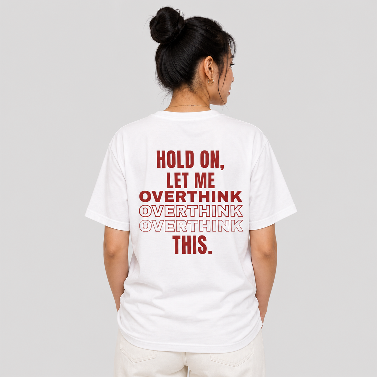 Woman from behind wearing a white t shirt with Hold On Let Me Overthink This printed on the back