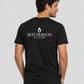 Man from behind wearing a black t shirt with Hot Person At Work printed on the back