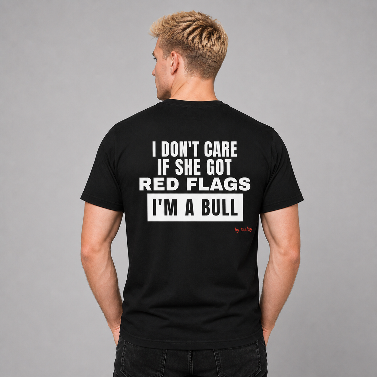 Man from behind wearing a black t shirt with I Don't Care If She Got Red Flags I'm A Bull printed on the back