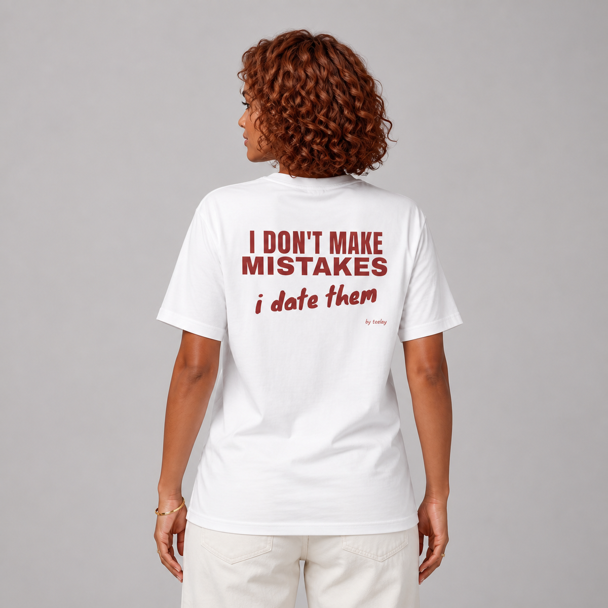 Woman from behind wearing a white t shirt with I Don't Make Mistakes I Date Them printed on the back