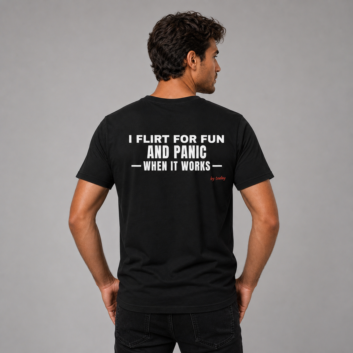 Man from behind wearing a black t shirt with I Flirt For Fun And Panic When It Works printed on the back