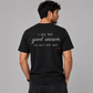 Man from behind wearing a black t shirt with I See No Good Reason To Act My Age printed on the back