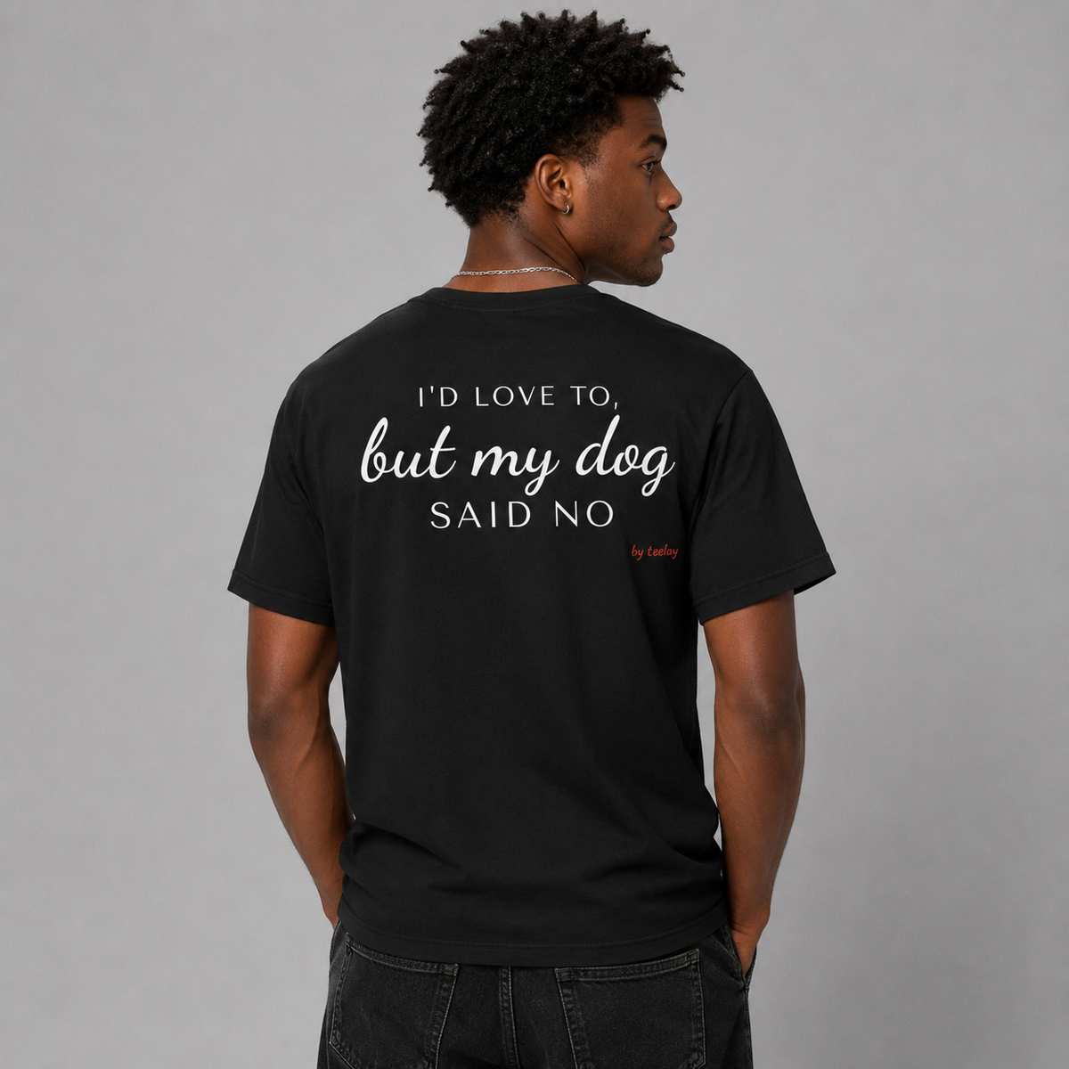 Man from behind wearing a black t shirt with I'd Love To But My Dog Said No printed on the back