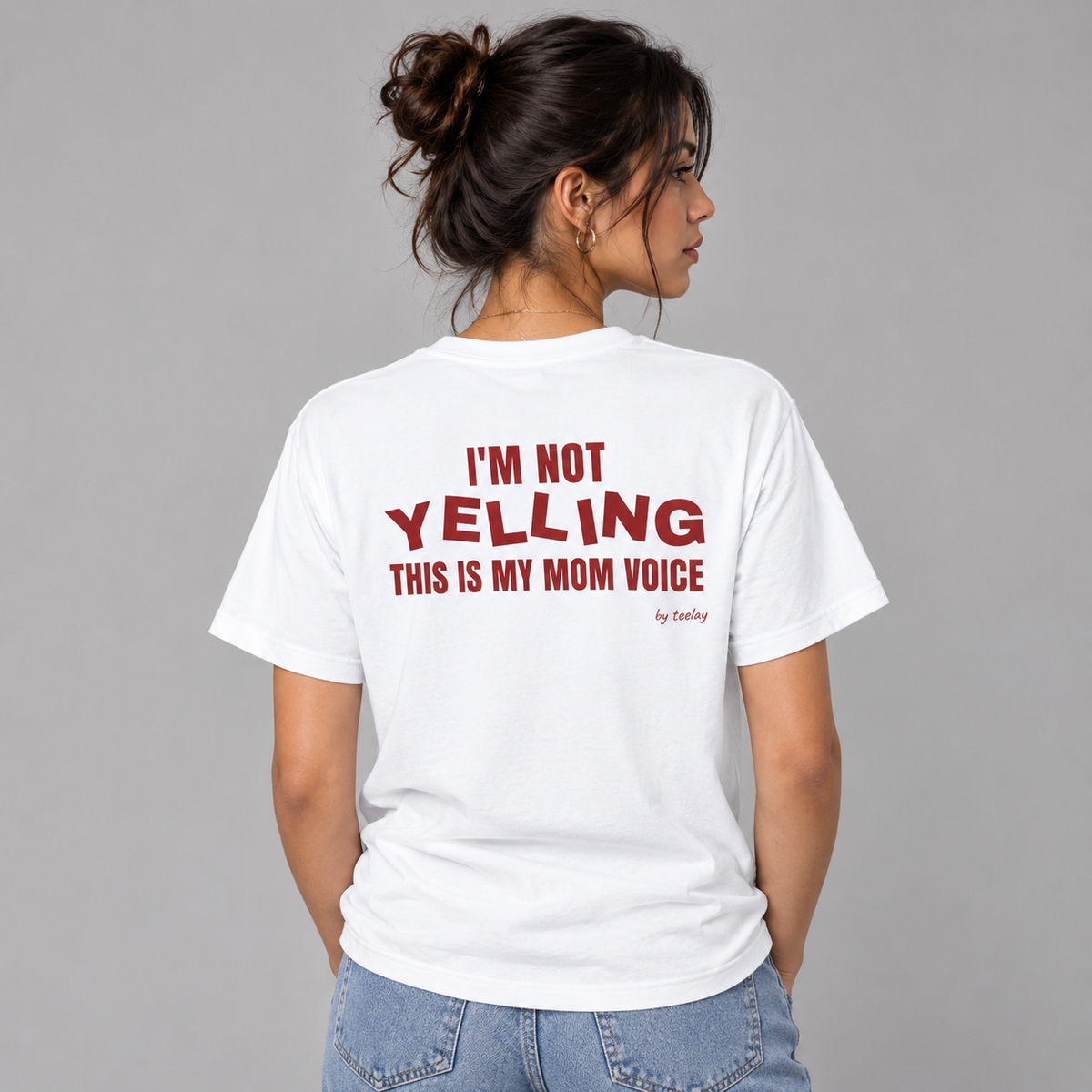Woman from behind wearing a white t shirt with I'm Not Yelling This Is My Mom Voice printed on the back