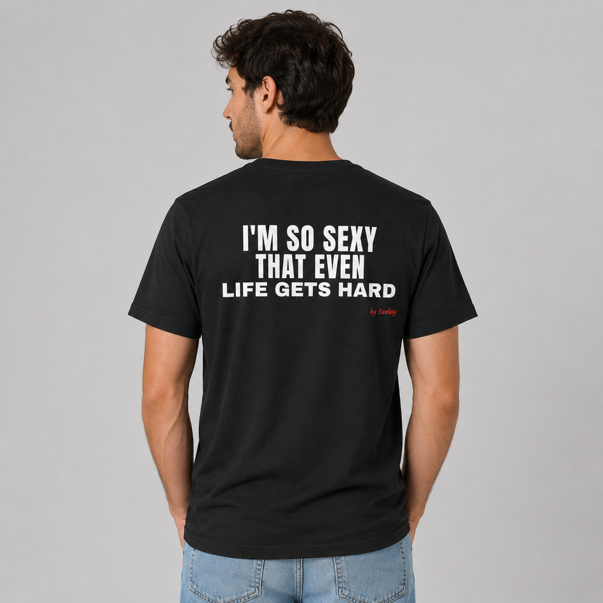 Man wearing a black funny tee with I'm So Sexy That Even Life Gets Hard printed on the back, rear view