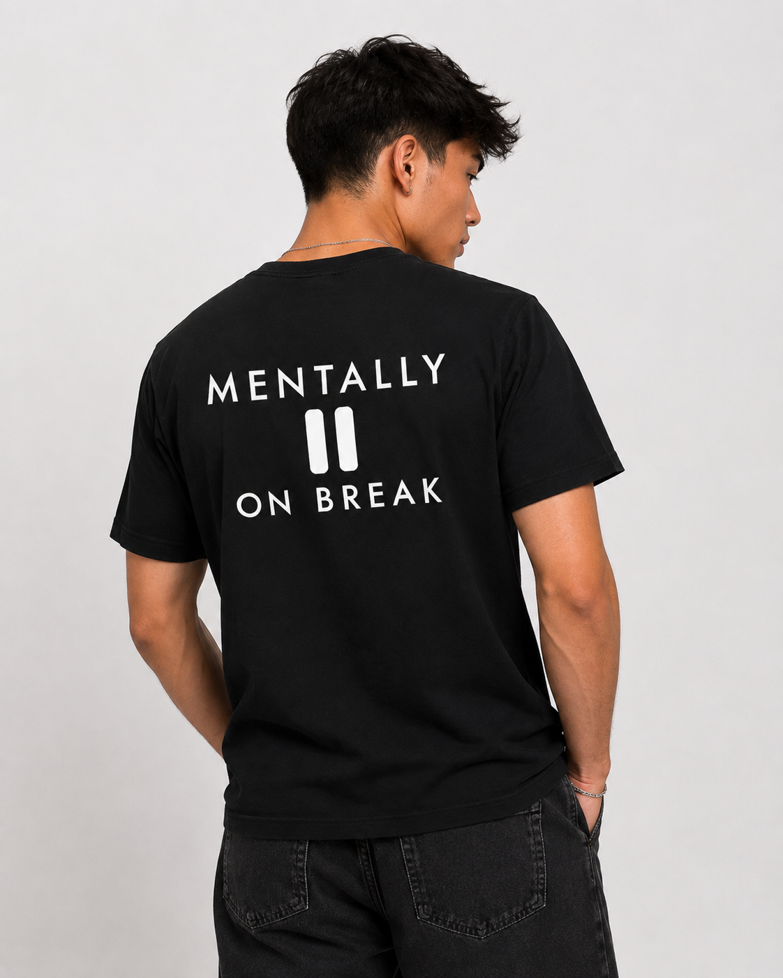 Man from behind wearing a black t shirt with Mentally On Break printed on the back