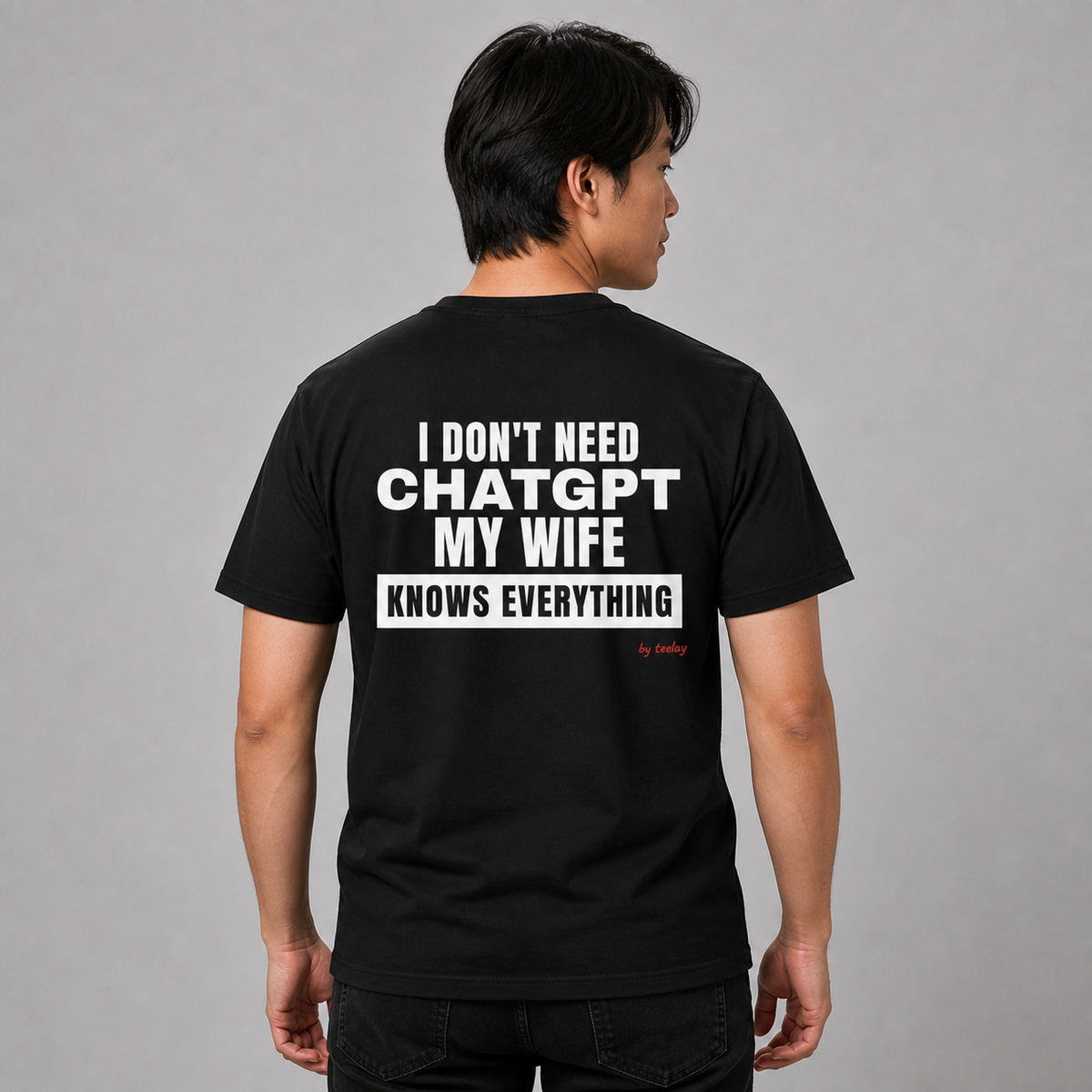 Man wearing a black graphic tee with My Wife Knows Everything printed on the back, rear view