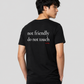 Man from behind wearing a black t shirt with Not Friendly Do Not Touch printed on the back
