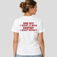 Woman from behind wearing a white t shirt with Some Days I Want A Man Everyday I Want Money printed on the back