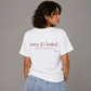 Woman from behind wearing a white t shirt with Sorry If I Looked I'm Not Interested printed on the back