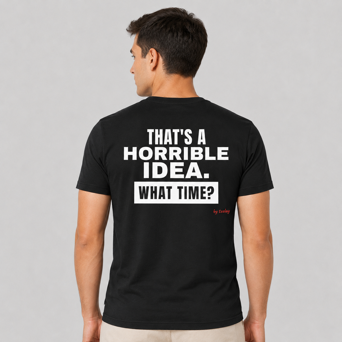 Man from behind wearing a black t shirt with That's A Horrible Idea What Time printed on the back