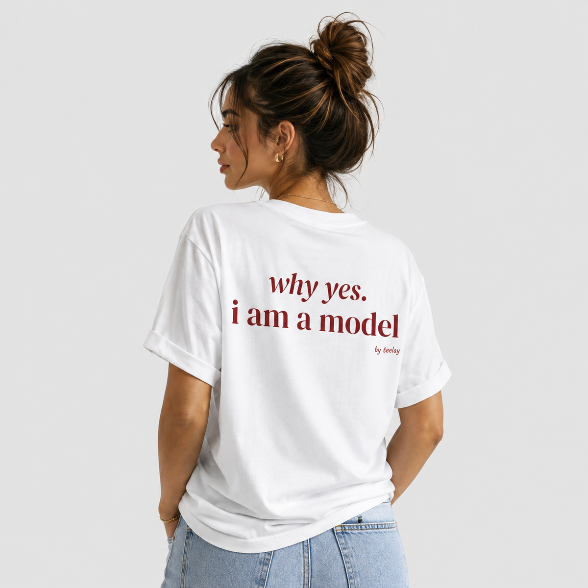 Woman from behind wearing a white t shirt with Why Yes I Am A Model printed on the back